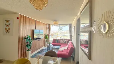 a living room with pink furniture and a glass table at Departamento con vista al mar y piscina - Pool One in Lima