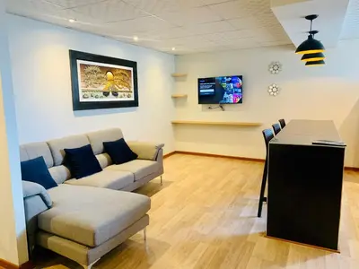 a living room with a couch and a tv at Apartamentos WANCA SUITES para 4, 5 y 6 huéspedes cochera muy cerca al Centro in Huancayo