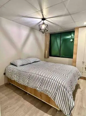a bedroom with a bed with a window and a ceiling at Apartamentos WANCA SUITES para 4, 5 y 6 huéspedes cochera muy cerca al Centro in Huancayo