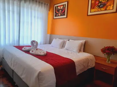 a bedroom with a bed with two swans on it at HOSTAL CASA INKAS in Cusco