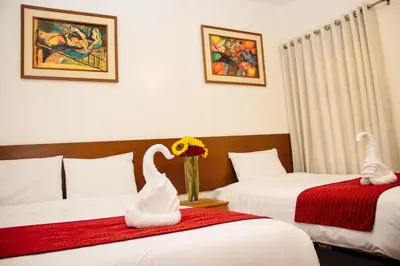 a hotel room with two beds with swans on them at HOSTAL CASA INKAS in Cusco