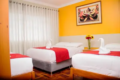 two beds in a room with two swans on them at HOSTAL CASA INKAS in Cusco