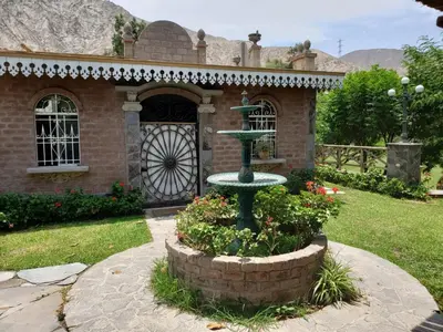 a house with a fountain in front of a building at Hacienda Santa María de Cieneguilla in Cieneguilla