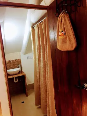 a bathroom with a towel hanging on a wooden wall at Kori Gems Inn in Cusco