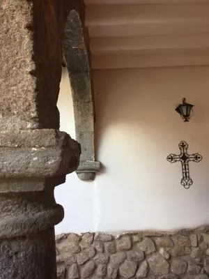 a cross on the side of a wall with a window at Kori Gems Inn in Cusco