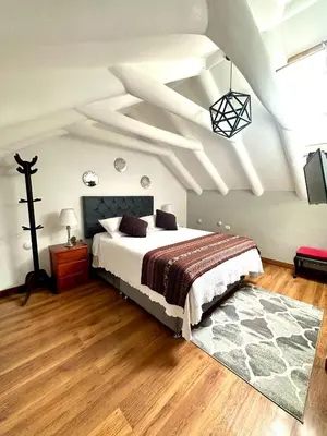 a bedroom with a large bed and a white ceiling at Kori Gems Inn in Cusco