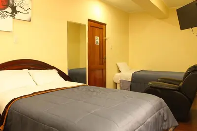 a hotel room with a bed and a chair at Hotel B&V in Huancayo