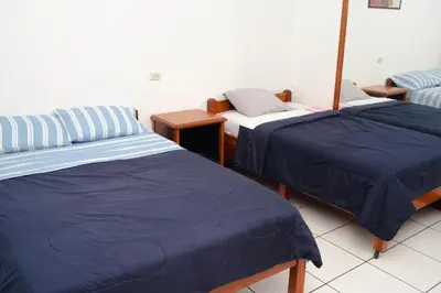 two beds in a room with blue sheets on them at Yaki Hostel in Lima