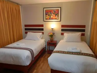 a hotel room with two beds and a picture on the wall at Raymi MachuPicchu in Machu Picchu