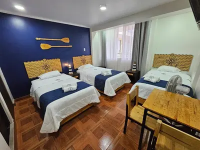 a hotel room with two beds and a table at EL FARO HOTEL in Chala