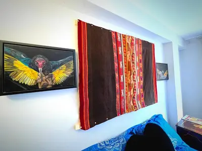 a painting of a bird is hanging on a wall at Kintu Apartamento cusco in Cusco