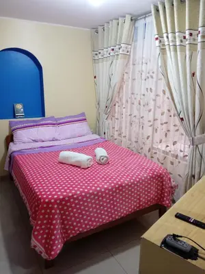 a bedroom with a bed with two towels on it at Mi hermosa Casita con baño y cocina privados in Lima