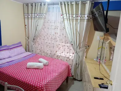a bedroom with a bed with a red and white table at Mi hermosa Casita con baño y cocina privados in Lima