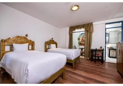 a hotel room with two beds and a window at Inkarri Regocijo Plaza in Cusco
