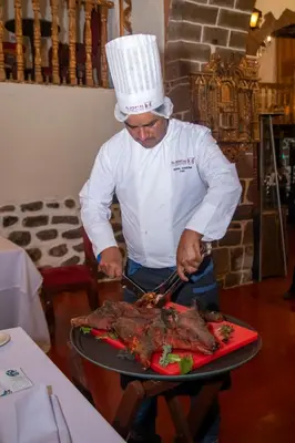 a man is cooking meat on a grill at Inkarri Regocijo Plaza in Cusco