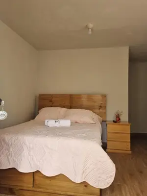 a bedroom with a large bed with a wooden headboard at URMA 2 in Barranca