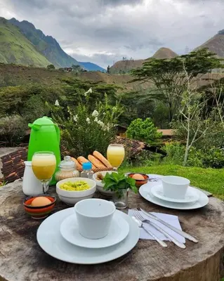 a table with plates of food and glasses of orange juice at Araplay Lodge in Santa Teresa