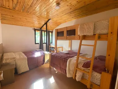 a room with two bunk beds in a cabin at Carol Haus in Oxapampa