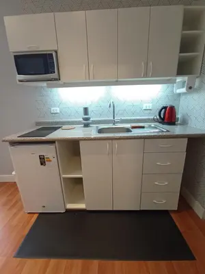 a kitchen with a sink and a microwave at Like/Home in Lima