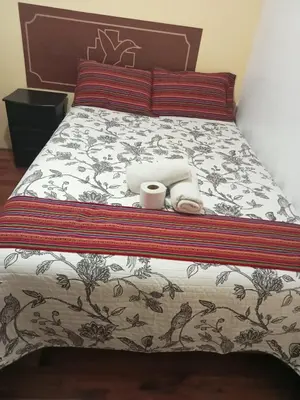 a bed with two towels and two cups on it at Hospedaje Apu Salka in Cusco