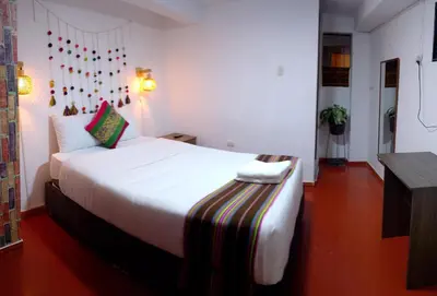 a bedroom with a large white bed in a room at Inca Town In in Cusco