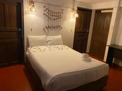 a bedroom with a large bed with white sheets at Inca Town In in Cusco