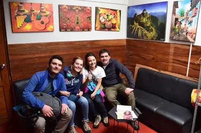 a group of people sitting on a couch in a room at Carlos Guest House Cusco in Cusco
