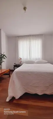 a bedroom with a large white bed with a window at HOSPEDAJE TURISTICO CHORRILLOS Sueños de Luna INN in Lima