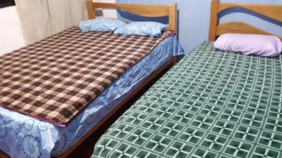 two beds sitting next to each other in a room at Hospedaje D'LEYDI in Lima