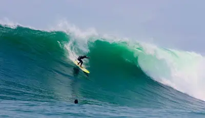 a man riding a wave on a surfboard in the ocean at Almar Punta Hermosa in Punta Hermosa