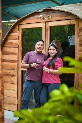 a man and a woman standing in front of a shed at Viñedo Sotelo - Hospedaje y Glamping in San Juan Bautista