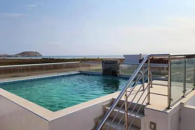 a swimming pool on top of a building with the ocean at Casa de Playa en Cerro Azul in Cerro Azul