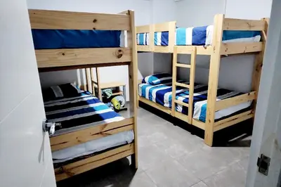 a room with two bunk beds with blue and white sheets at Casa de Playa en Cerro Azul in Cerro Azul