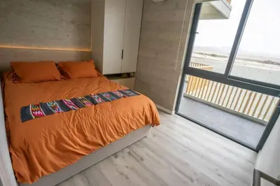 a bedroom with an orange bed and a large window at 3BR Paracas Kite Gym Work Oasis in Santo Domingo