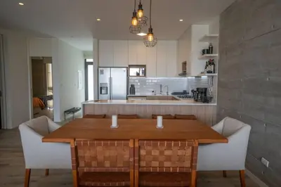 a kitchen with a wooden table and chairs in a kitchen at 3BR Paracas Kite Gym Work Oasis in Santo Domingo