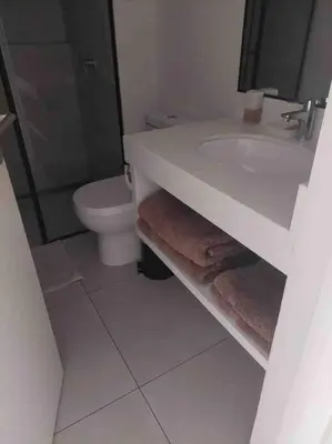 a white bathroom with a sink and a toilet at 3BR Paracas Kite Gym Work Oasis in Santo Domingo