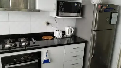 a kitchen with a stove and a refrigerator and a microwave at New! Modern 4BR Apartment Miraflores Lima in Lima