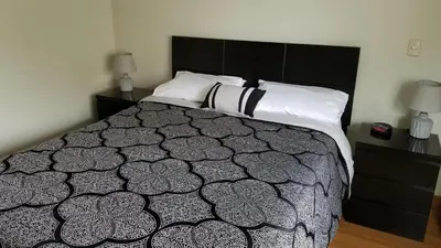 a bedroom with a black and white bed and two night stands at New! Modern 4BR Apartment Miraflores Lima in Lima