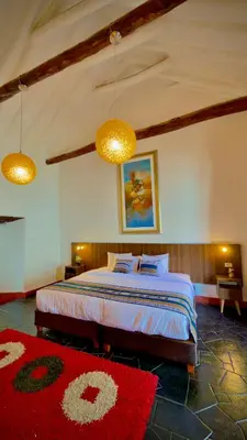 a bedroom with a bed with two lamps and a red rug at Andean Palace Boutique in Cusco