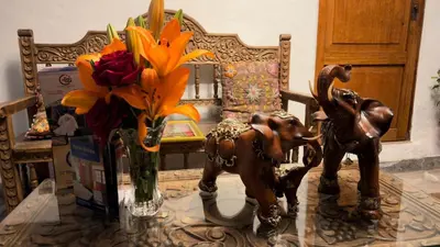 a table with a vase of flowers and an elephant statue at Andean Palace Boutique in Cusco