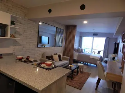 a living room with a kitchen and a living room with a couch at Loft de estreno, San Borja, muy centrico in Lima