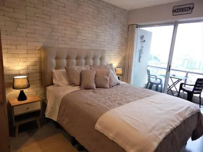 a bedroom with a large bed with a brick wall at Loft de estreno, San Borja, muy centrico in Lima