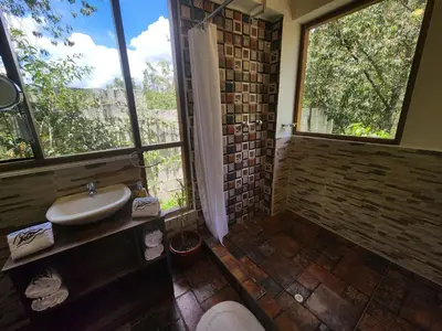 a bathroom with a sink and a large window at Spirit Of The River Lodge in Cusco