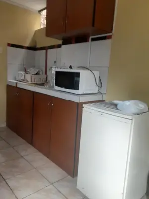 a small kitchen with a microwave and a refrigerator at ALAVA 245 in Lima