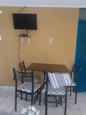 a dining room table with two chairs and a tv at ALAVA 245 in Lima