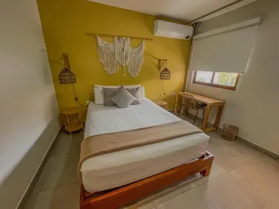 a bedroom with a large bed in a yellow wall at Viajero Huacachina Hostel in Ica