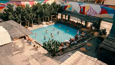 an overhead view of a swimming pool with people in it at Viajero Huacachina Hostel in Ica