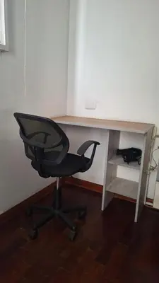 a desk with a black chair and a desk with a keyboard at Adri s House in Lima