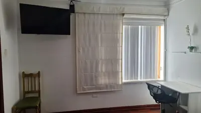 a room with a window with curtains and a chair at Adri s House in Lima