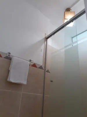 a bathroom with a shower and a white towel at Adri s House in Lima